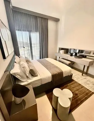 a bedroom with a bed and a desk with a television at Brand New Designer 1-Bedroom Apartment With Free Parking in Dubai
