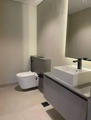 a bathroom with a white toilet and a sink at Brand New Designer 1-Bedroom Apartment With Free Parking in Dubai