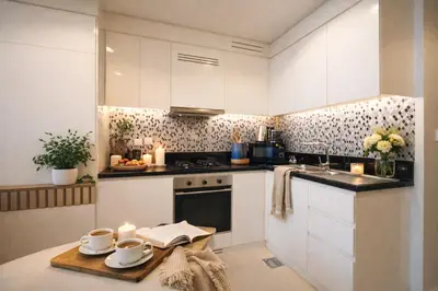 a kitchen with white cabinets and a table with candles at Keyrock Living - Dubai Oasis with Balcony Views in Dubai