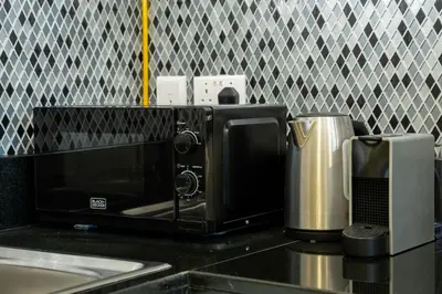 a microwave sitting on a kitchen counter next to a toaster at Keyrock Stylish Apartment in Dubai with Pool and Gym in Dubai