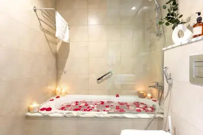 a bathroom with a tub with candles and red roses at Keyrock Stylish Apartment in Dubai with Pool and Gym in Dubai