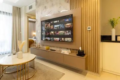 a living room with a large television on a wall at Keyrock Stylish Apartment in Dubai with Pool and Gym in Dubai