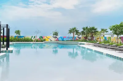 a large swimming pool with chairs and a building at KeyRock Elegant Aykon Apartment with City Views in Dubai