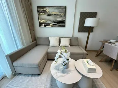 a living room with a couch and a table at Cozy 1br Apartment In Jvc Free Parking & Pool in Dubai