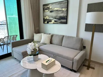 a living room with a couch and a table at Cozy 1br Apartment In Jvc Free Parking & Pool in Dubai