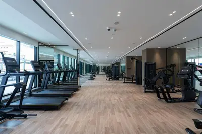 a gym with treadmills and elliptical machines at Cozy 1br Apartment In Jvc Free Parking & Pool in Dubai