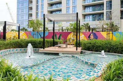 a pool with two fountains in front of a building at Keyrock Living - Luxe 2BR in Business Bay in Dubai