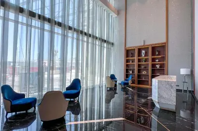 a waiting room with blue chairs and a large window at Keyrock Living - Luxe 2BR in Business Bay in Dubai