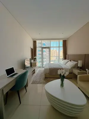 a bedroom with a bed and a table with a laptop at Seafront Escape Infinity Pool & Private Beach in Dubai