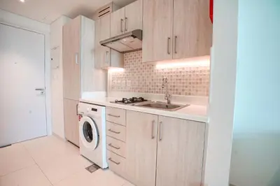 a kitchen with a sink and a washing machine at Seafront Escape Infinity Pool & Private Beach in Dubai