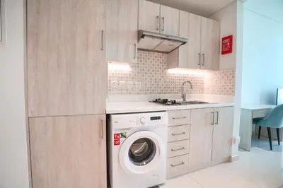a kitchen with a washing machine and a sink at Seafront Escape Infinity Pool & Private Beach in Dubai
