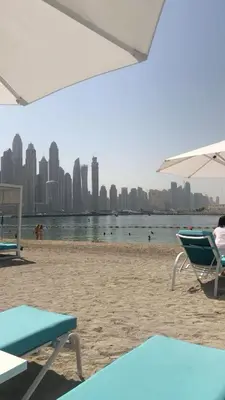 a person sitting in a chair on a beach at Seafront Escape Infinity Pool & Private Beach in Dubai
