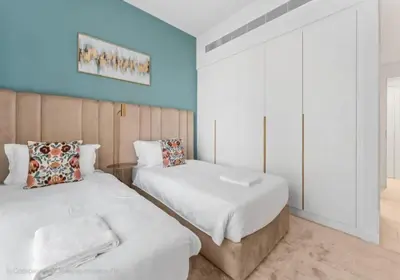 two beds in a room with blue walls at Sea-view 2BD apt with private beach in La Vie in Dubai