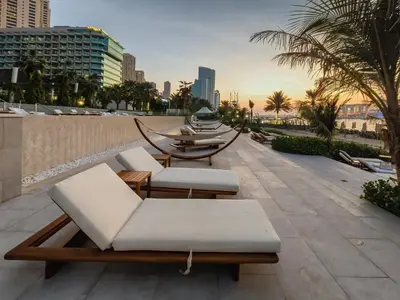 a patio with two lounge chairs and a table at Sea-view 2BD apt with private beach in La Vie in Dubai