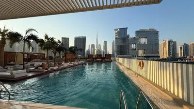 a swimming pool with lounge chairs and a city skyline at Upside living business bay best in Dubai