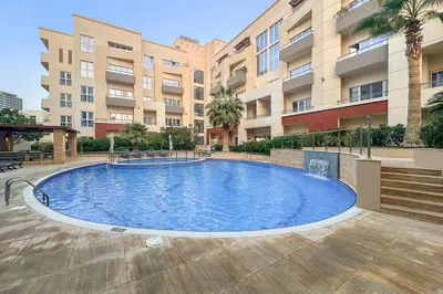 a large swimming pool in front of a building at Pool View 1BR in Dubai Free Parking Gym Near Parks and Golf in Dubai