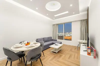 a living room with a table and a couch at Stylish 1BR with Balcony Near Marina Mall, Pool & Free Parking in Dubai