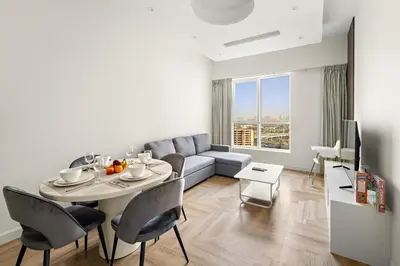 a living room with a table and a couch at Stylish 1BR with Balcony Near Marina Mall, Pool & Free Parking in Dubai