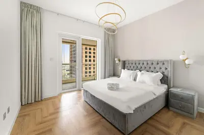 a bedroom with a large bed and a window at Stylish 1BR with Balcony Near Marina Mall, Pool & Free Parking in Dubai