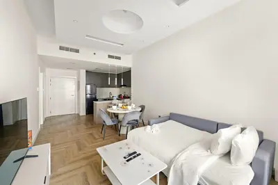a living room with a couch and a table at Stylish 1BR with Balcony Near Marina Mall, Pool & Free Parking in Dubai