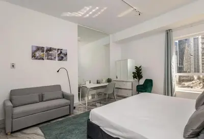 a bedroom with a bed and a chair and a mirror at Ahlan Premium Spacious Luxury Furnished 2 Bedroom Apartment Marina Beach JBR for Families and Groups in Dubai