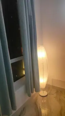 a lamp sitting in front of a window with a curtain at Ahlan Premium Spacious Luxury Furnished 2 Bedroom Apartment Marina Beach JBR for Families and Groups in Dubai