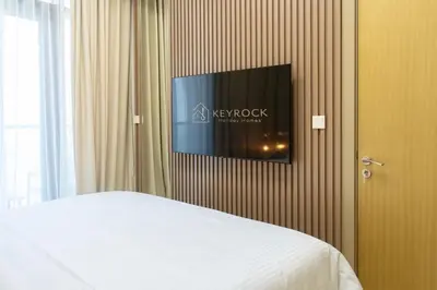 a bedroom with a bed and a tv on a wall at KeyRock Luxury 2BR Apartment with City Views in Dubai