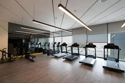 a gym with a row of treadmills and machines at Keyrock Living - Elevated Luxury in Business Bay in Dubai