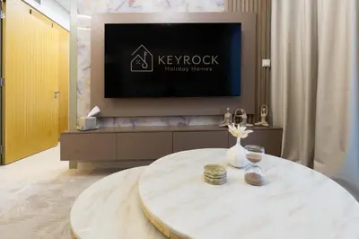 a living room with a round table with a tv at Keyrock Living - Elevated Luxury in Business Bay in Dubai