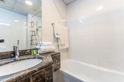 a bathroom with a sink and a bath tub at HAVN - Studio in Downtown, 10mins to Dubai Mall in Dubai