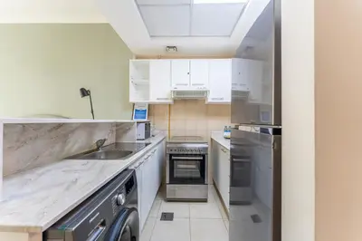 a kitchen with white cabinets and a sink at HAVN - Studio in Downtown, 10mins to Dubai Mall in Dubai
