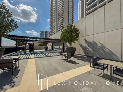 a patio with tables and chairs next to a building at LUX The Creek Palace Residence Suite in Dubai