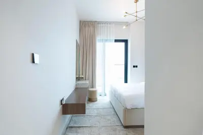 a white bedroom with a bed and a window at Keyrock Living - Binghatti Canal Luxury Stay in Dubai