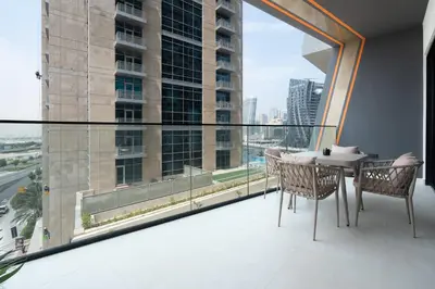 a balcony with a table and chairs and a large window at Keyrock Living - Binghatti Canal Luxury Stay in Dubai