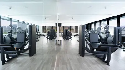 a gym with rows of treadmills in a building at Keyrock Living - Binghatti Canal Luxury Stay in Dubai