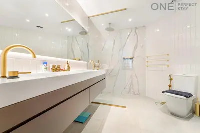 a white bathroom with a sink and a toilet at Stylish & Modern 3BR Apartment in Marina Stunning Views in Dubai