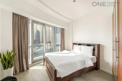 a bedroom with a bed and a large window at Stylish & Modern 3BR Apartment in Marina Stunning Views in Dubai