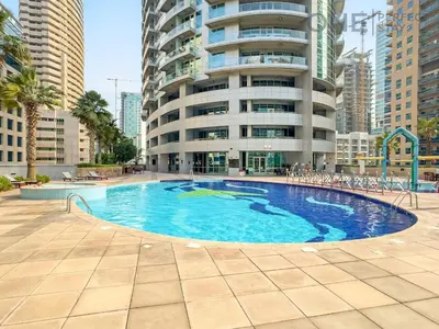a large swimming pool in front of a tall building at Stylish & Modern 3BR Apartment in Marina Stunning Views in Dubai