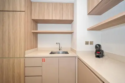 a small kitchen with a sink and wooden cabinets at Stylish 2BR Fully Furnished Unit at Business Bay in Dubai