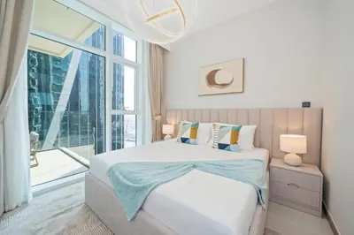 a bedroom with a bed and a large window at Stylish 2BR Fully Furnished Unit at Business Bay in Dubai
