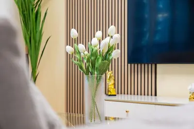 a vase filled with white flowers sitting on a table at Luxury 3 bedroom with Stunning Full Marina View in Dubai in Dubai
