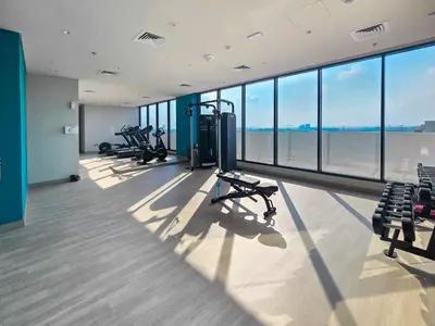 a gym with several treadmills and benches in a building at EasyGo- Splendid Apartments in Al Meydan Living in Dubai