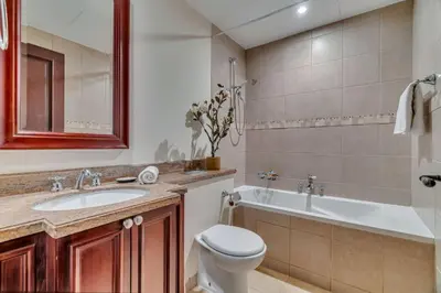 a bathroom with a toilet and a sink and a tub at GuestReady - Downtown oasis with Burj Khalifa view in Dubai