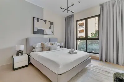 a white bedroom with a large bed and a window at GuestReady - Downtown oasis with Burj Khalifa view in Dubai