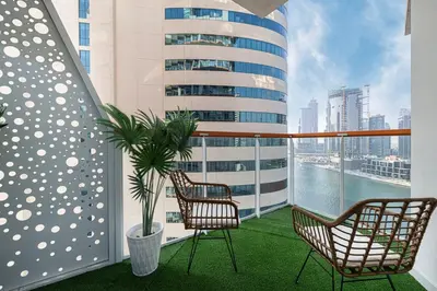 a balcony with two chairs and a potted plant at Panoramic! Burj Khalifa and Canal View! in Dubai
