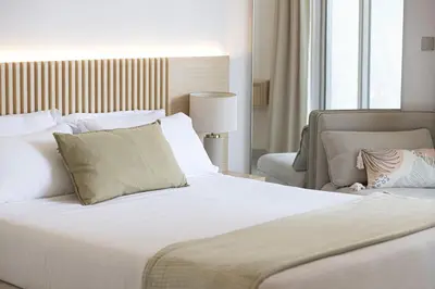 a bedroom with a large white bed and a chair at Panoramic! Burj Khalifa and Canal View! in Dubai