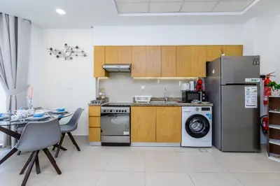 a kitchen with a refrigerator and a table and chairs at Burj Khalifa View - 1BR in Bellevue Tower 2, Downtown - Allsopp & Allsopp in Dubai