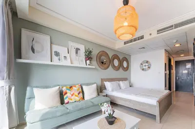 a living room with a couch and a bed at HAVN - Studio Apartment in Goldcrest Views, JLT in Dubai