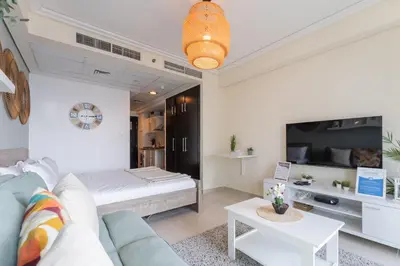 a living room with a couch and a bed at HAVN - Studio Apartment in Goldcrest Views, JLT in Dubai