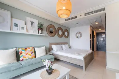 a living room with a bed and a couch at HAVN - Studio Apartment in Goldcrest Views, JLT in Dubai